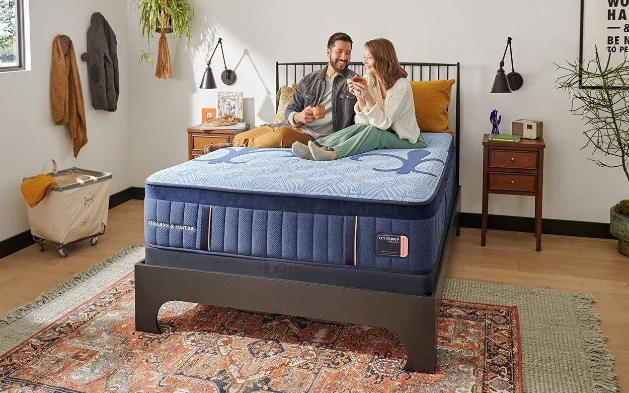 A couple lounging on a Lux Hybrid mattress