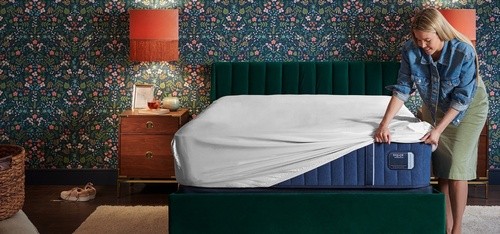 Woman putting Sheet Set On A Estate Mattress