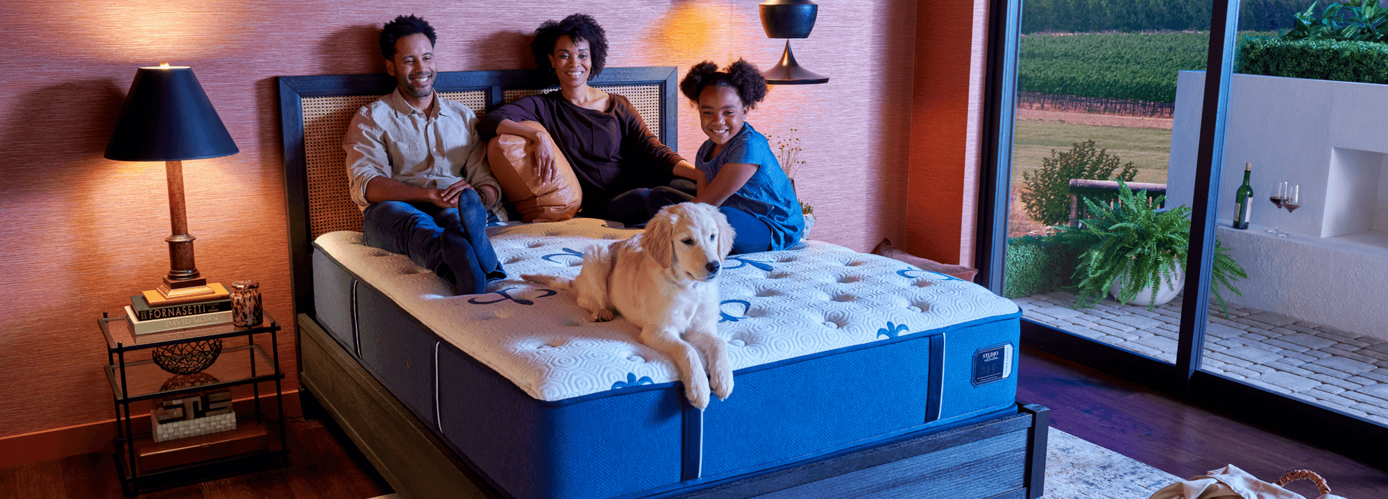 Studio tight top mattress in a dressed room, with friends lounging on top.