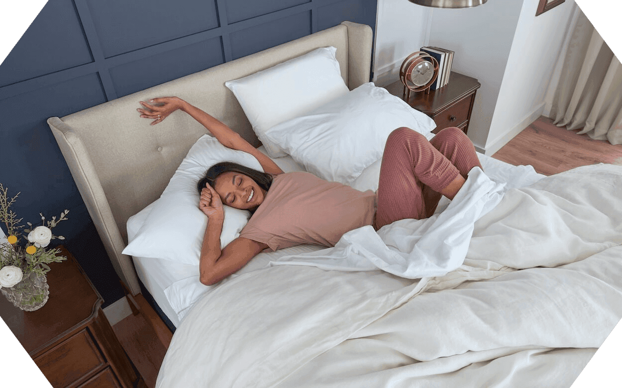 Octagon shaped image of woman laying in a dressed bed